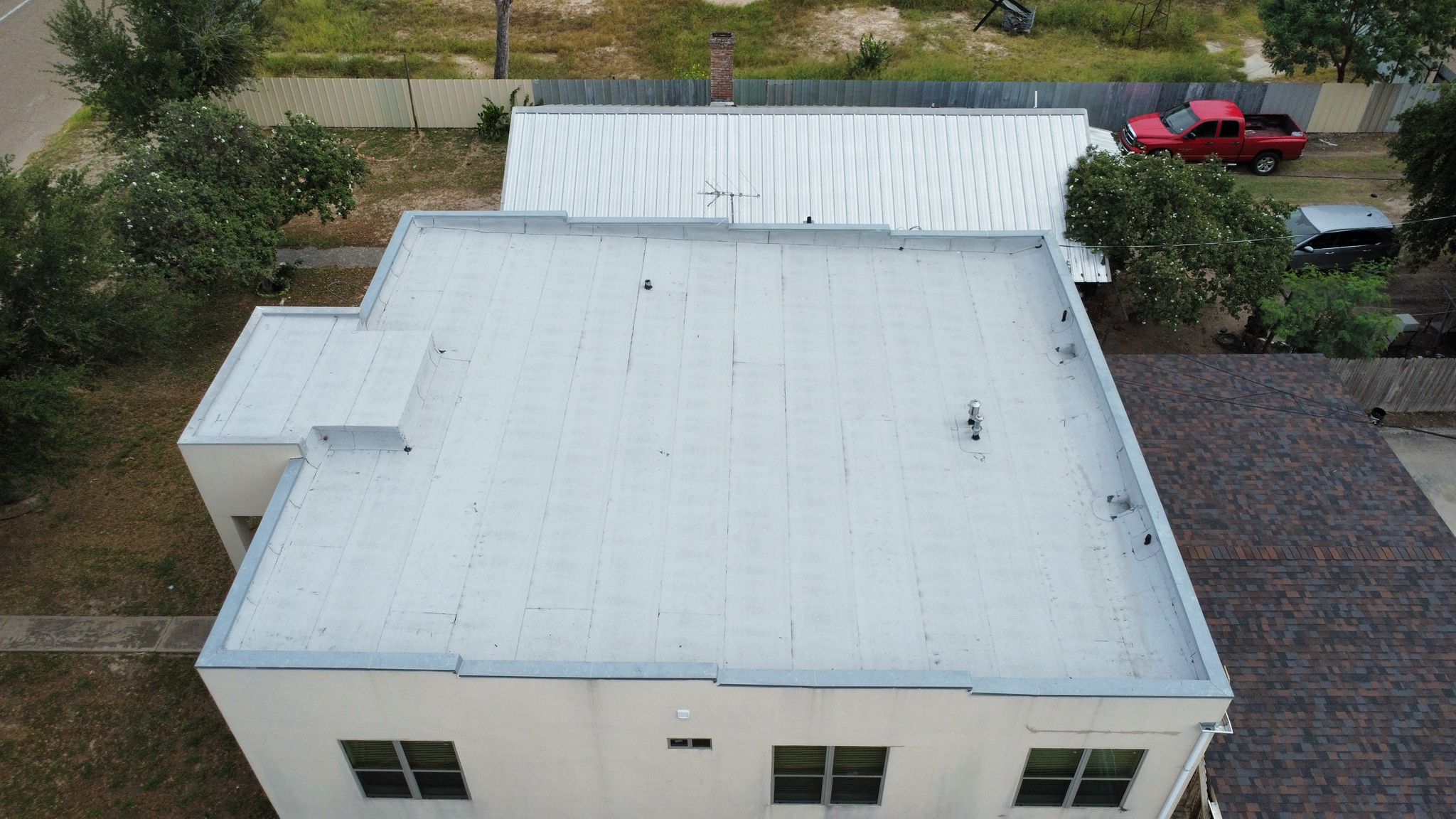 Metal roofing and asphalt shingle roofing side by side on a Rio Grande Valley property