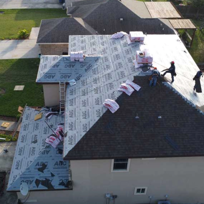 contractors on top of a brown roofing replacing some tiles