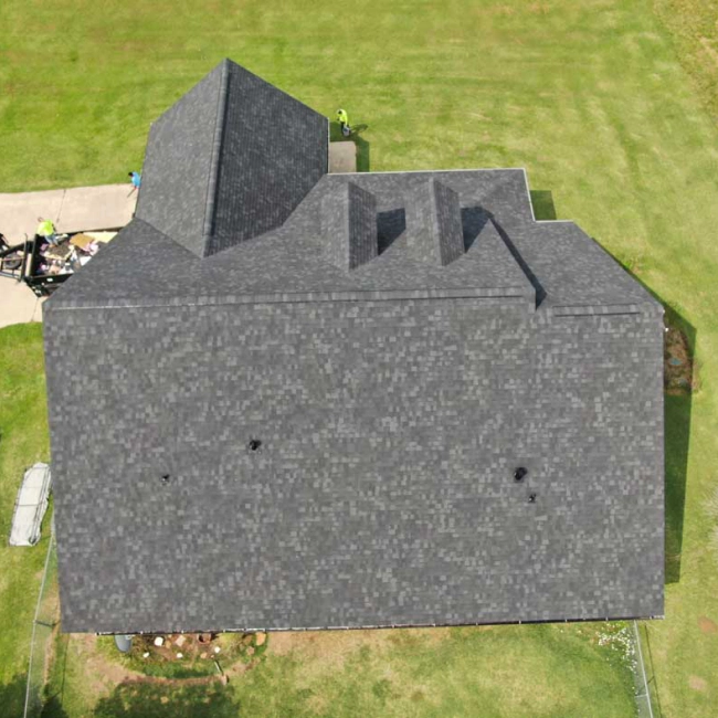 house with a dark grey roofing with patio around