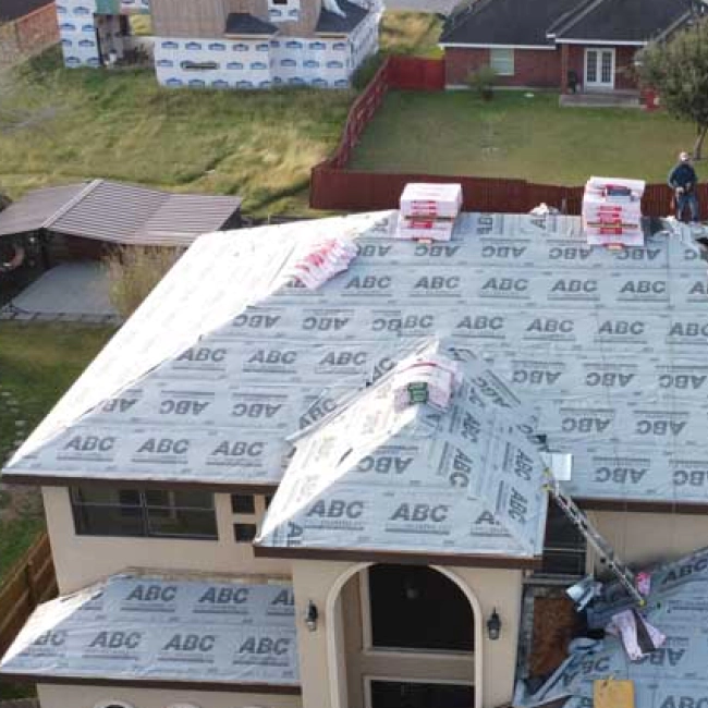 roofing of a house being repaired with some materials on top and contractors
